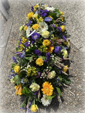 Coffin spray spring colours with dried corn